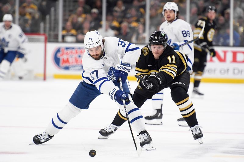 Apr 30, 2024; Boston, Massachusetts, USA; Toronto Maple Leafs defenseman Timothy Liljegren (37) reaches for the puck in front of Boston Bruins center Trent Frederic (11) during the first period in game five of the first round of the 2024 Stanley Cup Playoffs at TD Garden. Mandatory Credit: Bob DeChiara-USA TODAY Sports