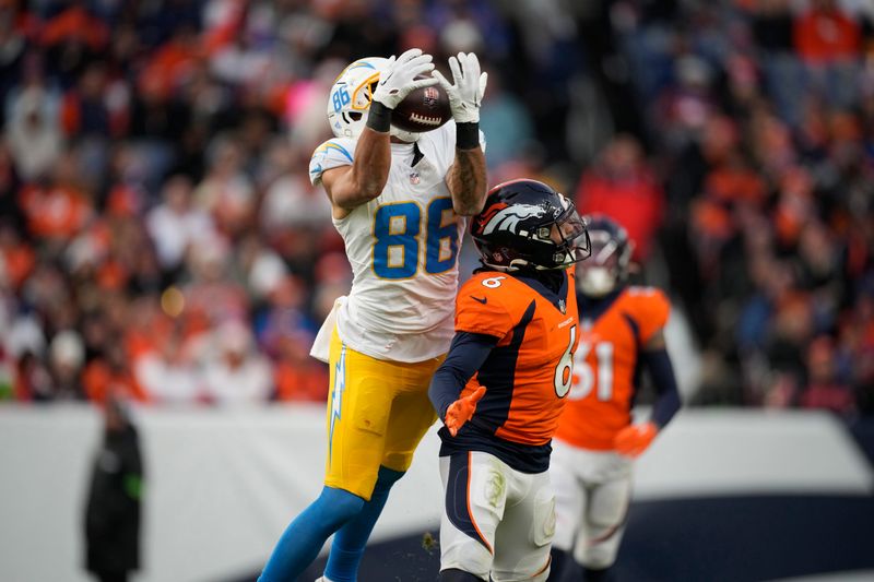 Los Angeles Chargers wide receiver Keelan Doss (86) drops pass as Denver Broncos safety P.J. Locke (6) covers in the second half of an NFL football game in Empower Field at Mile High Sunday, Dec. 31, 2023, in Denver. (AP Photo/David Zalubowski)