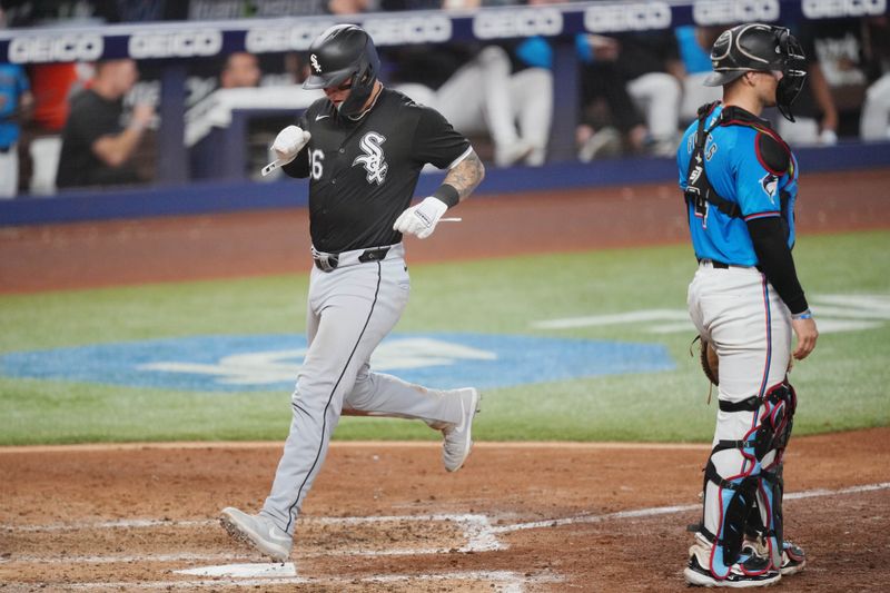Jul 7, 2024; Miami, Florida, USA;  Chicago White Sox catcher Korey Lee (26) scores a run in the sixth inning as Miami Marlins catcher Nick Fortes (4) looks on at loanDepot Park. Mandatory Credit: Jim Rassol-USA TODAY Sports