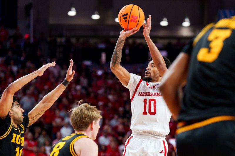 Mar 8, 2026; Lincoln, Nebraska, USA; Nebraska Cornhuskers guard Jamarques Lawrence (10) shoots against Iowa Hawkeyes guard Kael Combs (11) and forward Cooper Koch (8) during the first half at Pinnacle Bank Arena. Mandatory Credit: Dylan Widger-Imagn Images