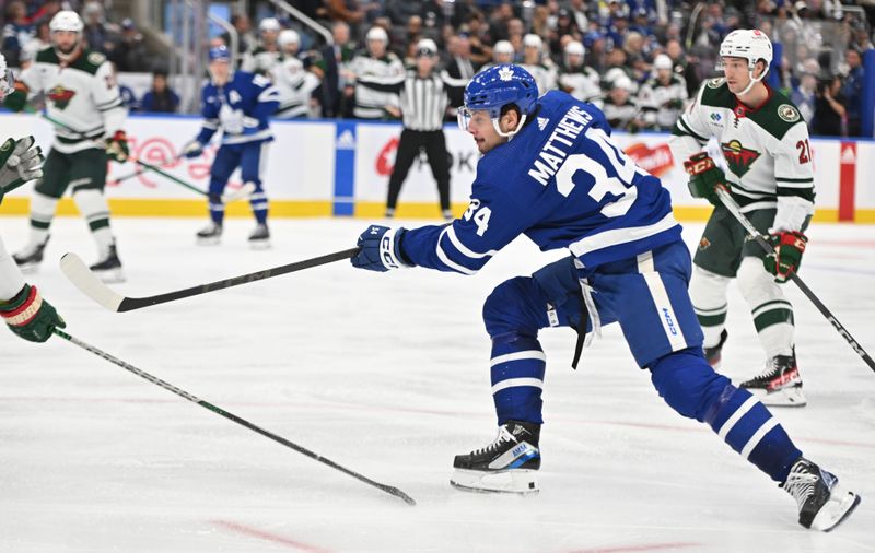 Oct 14, 2023; Toronto, Ontario, CAN;   Toronto Maple Leafs forward Auston Matthews (34) shoots the puck against the Minnesota Wild in the third period at Scotiabank Arena. Mandatory Credit: Dan Hamilton-USA TODAY Sports