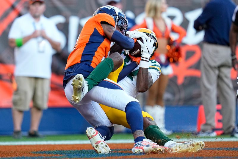 Green Bay Packers wide receiver Romeo Doubs, right, catches a touchdown pass against Denver Broncos cornerback Pat Surtain II during the second half of an NFL football game in Denver, Sunday, Oct. 22, 2023. (AP Photo/Jack Dempsey)