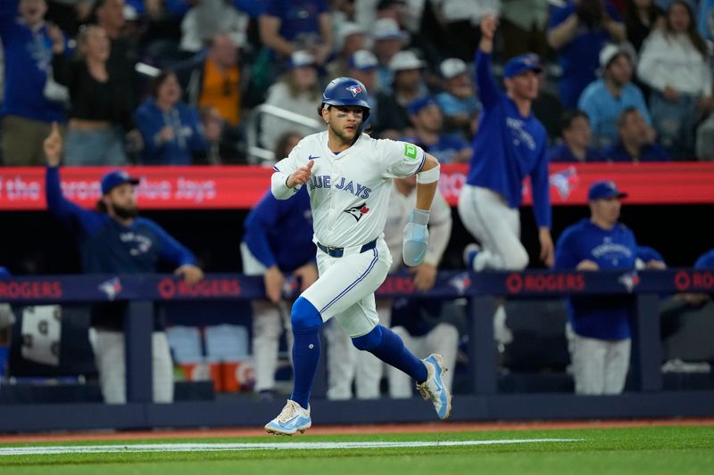 May 10, 2024; Toronto, Ontario, CAN; Toronto Blue Jays shortstop Bo Bichette (11) scores on a single by second baseman Isiah Kiner-Falefa (not pictured) against the Minnesota Twins during the ninth inning at Rogers Centre. Mandatory Credit: John E. Sokolowski-USA TODAY Sports