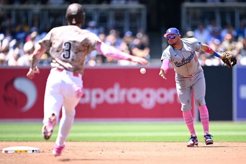 May 12, 2024; San Diego, California, USA; Los Angeles Dodgers second baseman Miguel Rojas (11) tosses the ball to second base to force out San Diego Padres center fielder Jackson Merrill (3) during the second inning at Petco Park. Mandatory Credit: Orlando Ramirez-USA TODAY Sports