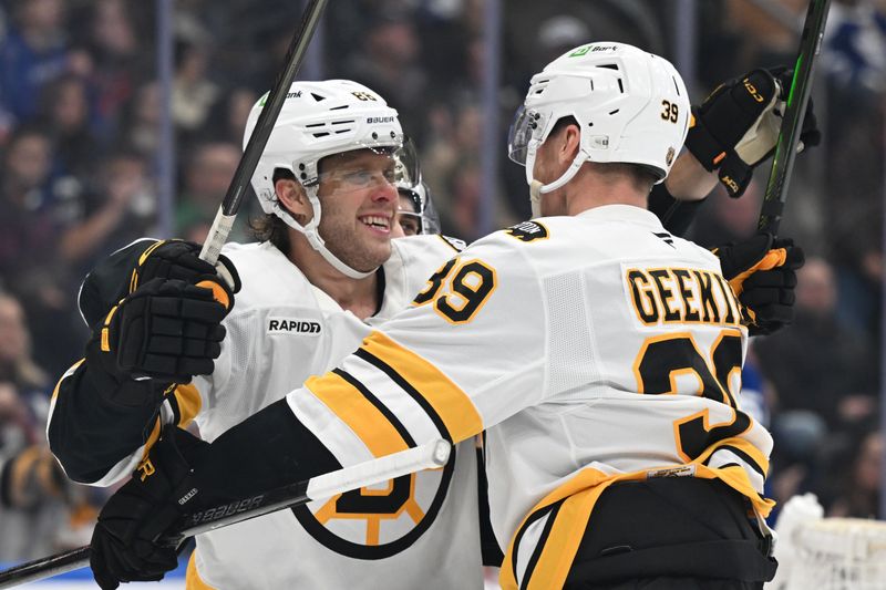 Nov 8, 2025; Toronto, Ontario, CAN;  Boston Bruins forward David Pastrnak (88) celebrates with forward Morgan Geekie (39) after scoring a goal against the Toronto Maple Leafs in the second period at Scotiabank Arena. Mandatory Credit: Dan Hamilton-Imagn Images