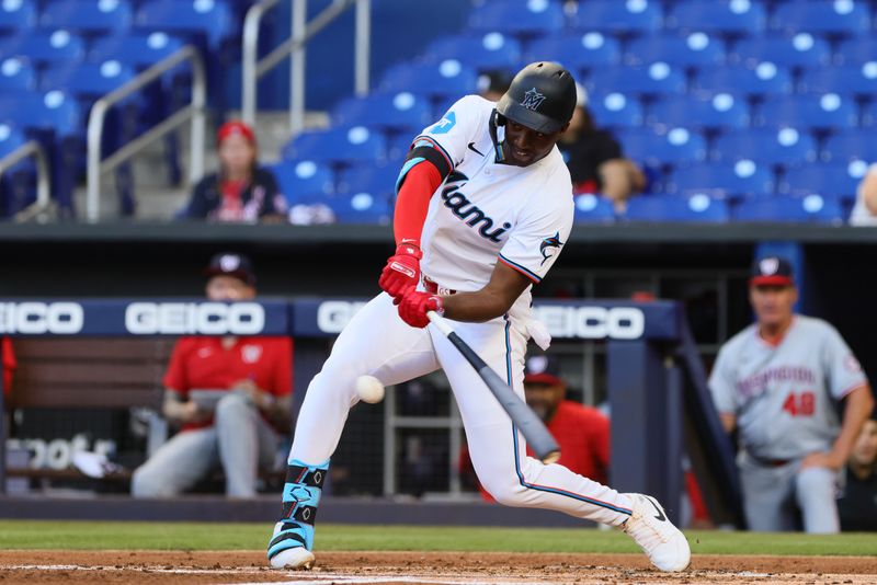 Apr 29, 2024; Miami, Florida, USA; Miami Marlins right fielder Jesus Sanchez (12) hits a single against the Washington Nationals during the first inning at loanDepot Park. Mandatory Credit: Sam Navarro-USA TODAY Sports