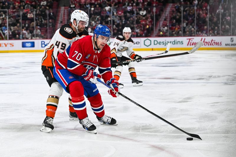 Feb 13, 2024; Montreal, Quebec, CAN; Montreal Canadiens left wing Tanner Pearson (70) plays the puck against Anaheim Ducks left wing Max Jones (49) during the third period at Bell Centre. Mandatory Credit: David Kirouac-USA TODAY Sports