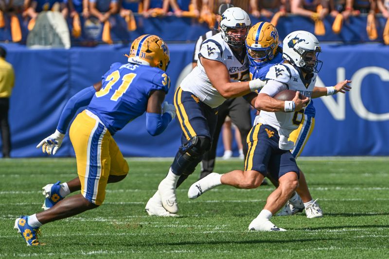 Sep 14, 2024; Pittsburgh, Pennsylvania, USA; West Virginia Mountaineers quarterback Garrett Greene (6) runs while being chased by Pittsburgh Panthers linebacker Rasheem Biles (31) during the first quarter at Acrisure Stadium. Mandatory Credit: Barry Reeger-Imagn Images