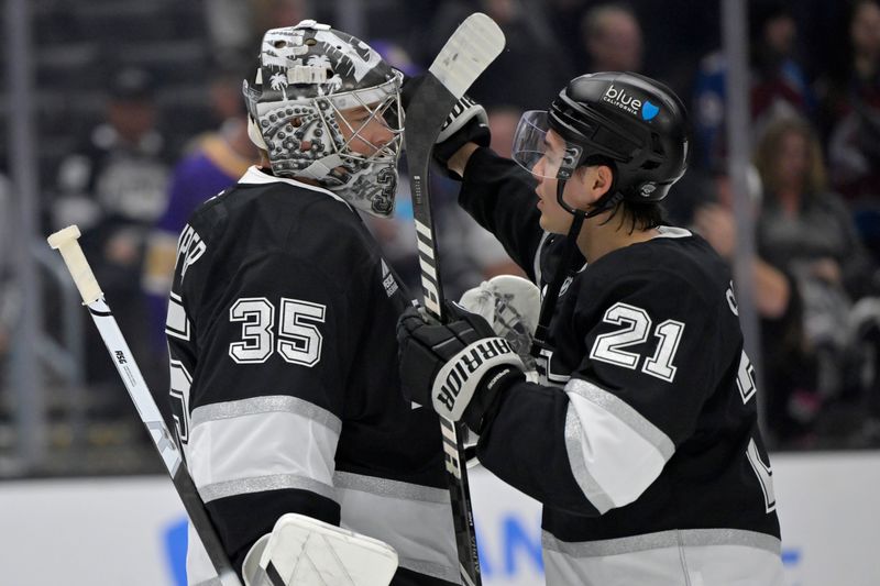 Apr 12, 2025; Los Angeles, California, USA; Los Angeles Kings goaltender Darcy Kuemper (35) is congratulated by defenseman Jordan Spence (21) following the game against the Colorado Avalanche at Crypto.com Arena. Mandatory Credit: Jayne Kamin-Oncea-Imagn Images