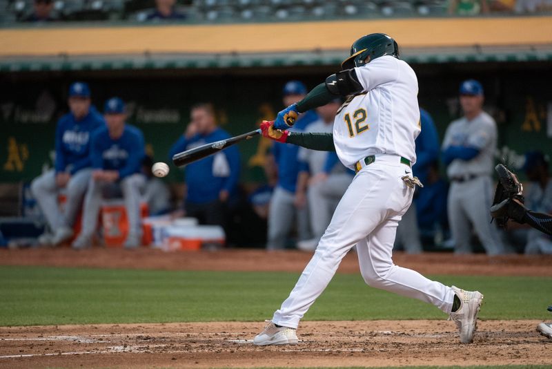 Aug 22, 2023; Oakland, California, USA; Oakland Athletics shortstop Aledmys Diaz (12) hits an rbi double during the third inning against the Kansas City Royals at Oakland-Alameda County Coliseum. Mandatory Credit: Ed Szczepanski-USA TODAY Sports