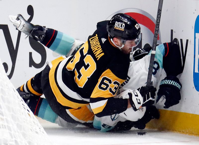 Jan 15, 2024; Pittsburgh, Pennsylvania, USA; Pittsburgh Penguins left wing Radim Zohorna (63) checks Seattle Kraken defenseman Brian Dumoulin (8) during the third period at PPG Paints Arena. Mandatory Credit: Charles LeClaire-USA TODAY Sports