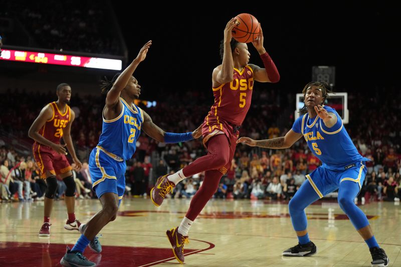 Jan 27, 2024; Los Angeles, California, USA; Southern California Trojans guard Boogie Ellis (5) passes the ball against UCLA Bruins guard Dylan Andrews (2) and guard Brandon Williams (5) in the second half at Galen Center. Mandatory Credit: Kirby Lee-USA TODAY Sports