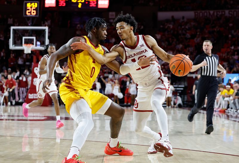 Jan 6, 2024; Norman, Oklahoma, USA; Oklahoma Sooners guard Milos Uzan (12) drives against Iowa State Cyclones forward Tre King (0) during the second half at Lloyd Noble Center. Mandatory Credit: Alonzo Adams-USA TODAY Sports