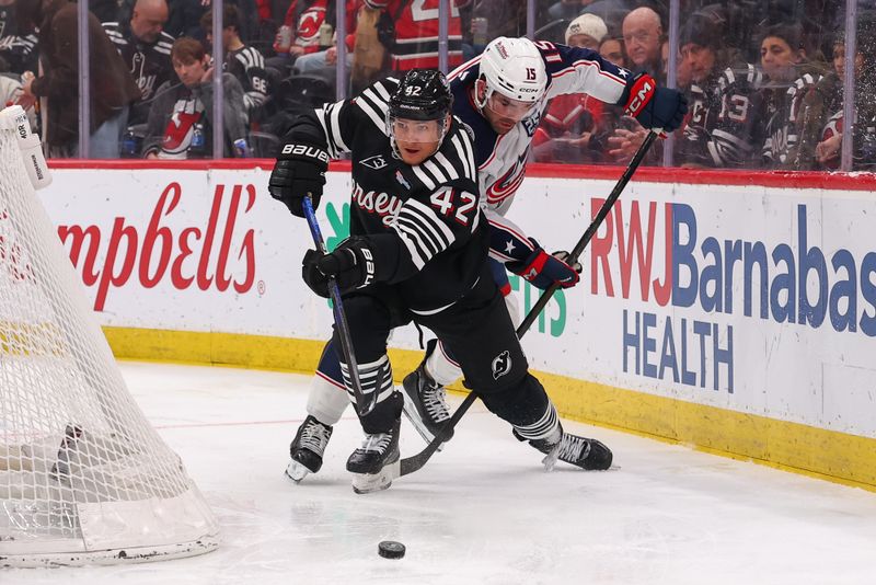 Feb 3, 2026; Newark, New Jersey, USA; New Jersey Devils right wing Maxim Tsyplakov (42) passes the puck as Columbus Blue Jackets defenseman Dante Fabbro (15) defends during the second period at Prudential Center. Mandatory Credit: Ed Mulholland-Imagn Images