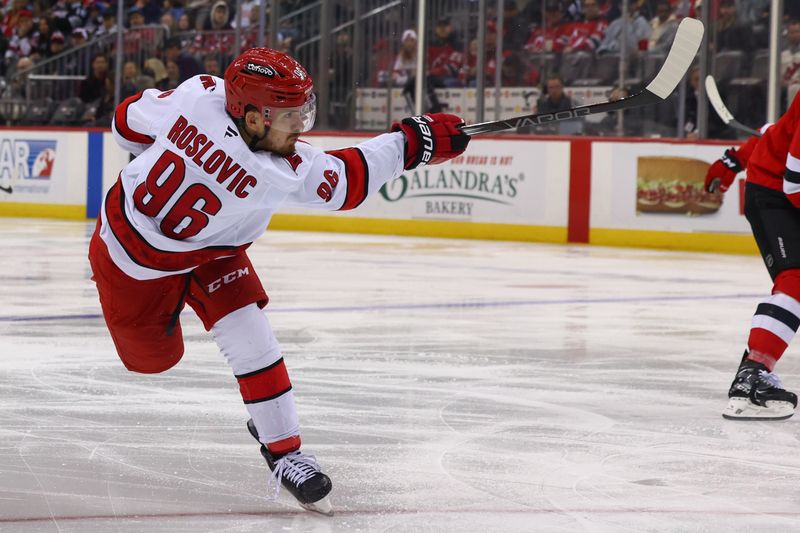 Nov 21, 2024; Newark, New Jersey, USA; Carolina Hurricanes center Jack Roslovic (96) shoots the puck against the New Jersey Devils during the third period at Prudential Center. Mandatory Credit: Ed Mulholland-Imagn Images