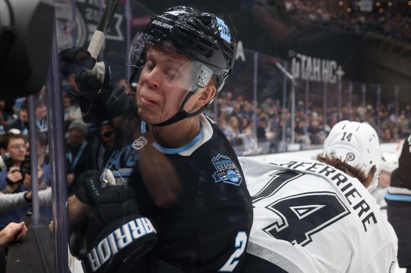 Apr 3, 2025; Salt Lake City, Utah, USA; Utah Hockey Club defenseman Olli Maatta (2) is hit into the glass by Los Angeles Kings right wing Alex Laferriere (14) during the second period at Delta Center. Mandatory Credit: Rob Gray-Imagn Images