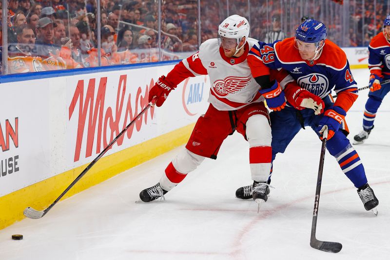 Jan 30, 2025; Edmonton, Alberta, CAN; Detroit Red Wings forward Andrew Copp (18) protects the puck from Edmonton Oilers defensemen Ty Emberson (49) during the second period at Rogers Place. Mandatory Credit: Perry Nelson-Imagn Images