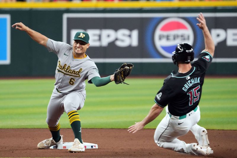 Jun 30, 2024; Phoenix, Arizona, USA; Oakland Athletics infielder Aledmys Díaz (6) fields a throw to force out Arizona Diamondbacks outfielder Randal Grichuk (15) at second during the seventh inning at Chase Field. Mandatory Credit: Joe Camporeale-USA TODAY Sports
