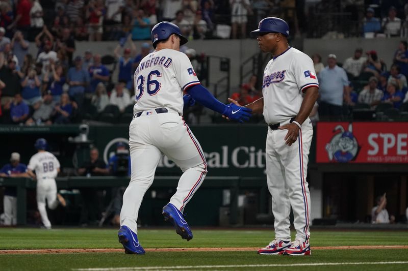 May 17, 2025; Arlington, Texas, USA; Texas Rangers outfielder Wyatt Langford (36) shakes the hand third base coach Tony Beasley (27) after hitting a solo home run during the seventh inning against the Houston Astros at Globe Life Field. Mandatory Credit: Raymond Carlin III-Imagn Images