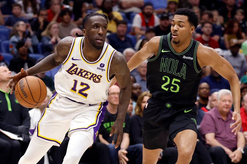 NEW ORLEANS, LOUISIANA - APRIL 14: Taurean Prince #12 of the Los Angeles Lakers drives against Trey Murphy III #25 of the New Orleans Pelicans during the second half at Smoothie King Center on April 14, 2024 in New Orleans, Louisiana.  NOTE TO USER: User expressly acknowledges and agrees that, by downloading and or using this photograph, User is consenting to the terms and conditions of the Getty Images License Agreement. (Photo by Tyler  Kaufman/Getty Images)