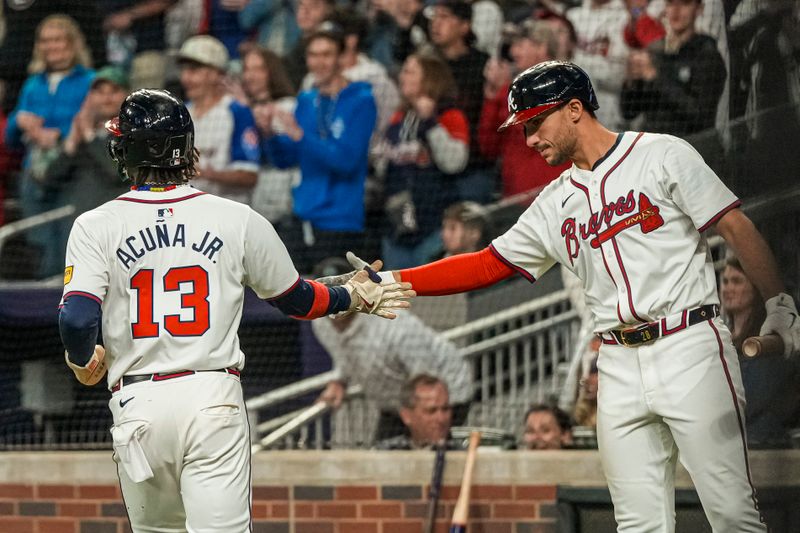 Apr 21, 2024; Cumberland, Georgia, USA; Atlanta Braves right fielder Ronald Acuna Jr (13) reacts with third baseman Austin Riley (27) after scoring a run against the Texas Rangers during the eighth inning at Truist Park. Mandatory Credit: Dale Zanine-USA TODAY Sports