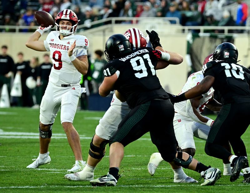 Nov 2, 2024; East Lansing, Michigan, USA;  Indiana Hoosiers quarterback Kurtis Rourke (9) looks for a receiver during the fourth quarter against the Michigan State Spartans at Spartan Stadium. Mandatory Credit: Dale Young-Imagn Images