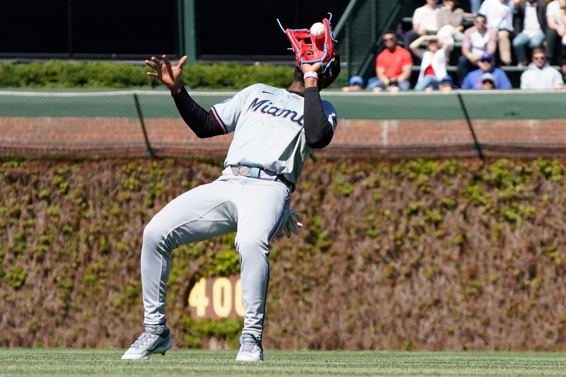 Apr 19, 2024; Chicago, Illinois, USA; Miami Marlins outfielder Jesús Sánchez (12) makes a catch on Chicago Cubs Patrick Wisdom (not pictured) during the sixth inning at Wrigley Field. Mandatory Credit: David Banks-USA TODAY Sports