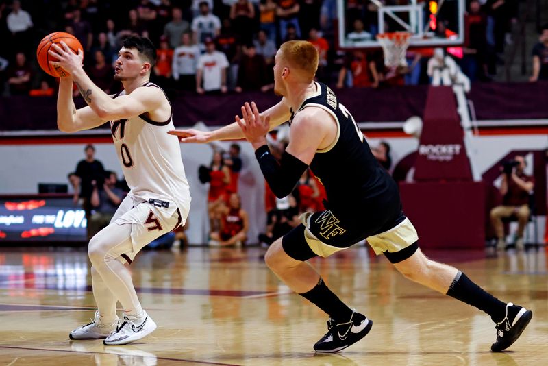 Mar 2, 2024; Blacksburg, Virginia, USA; Virginia Tech Hokies guard Hunter Cattoor (0) shoots the ball against Wake Forest Demon Deacons guard Cameron Hildreth (2) during the second half at Cassell Coliseum. Mandatory Credit: Peter Casey-USA TODAY Sports