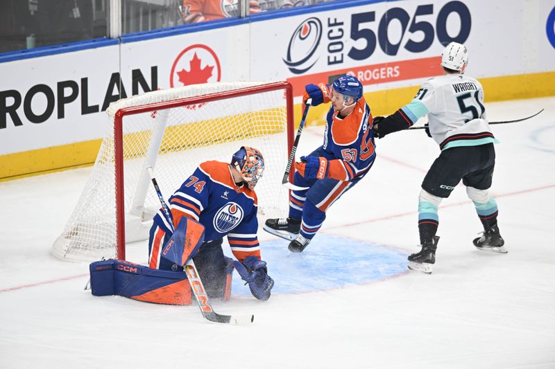 Mar 22, 2025; Edmonton, Alberta, CAN;  Edmonton Oilers goalie Stuart Skinner (74) battles for the puck with Oilers centre Jeff Skinner (53) as Seattle Kraken centre Shane Wright (51) skates by during the first period at Rogers Place. Mandatory Credit: Walter Tychnowicz-Imagn Images