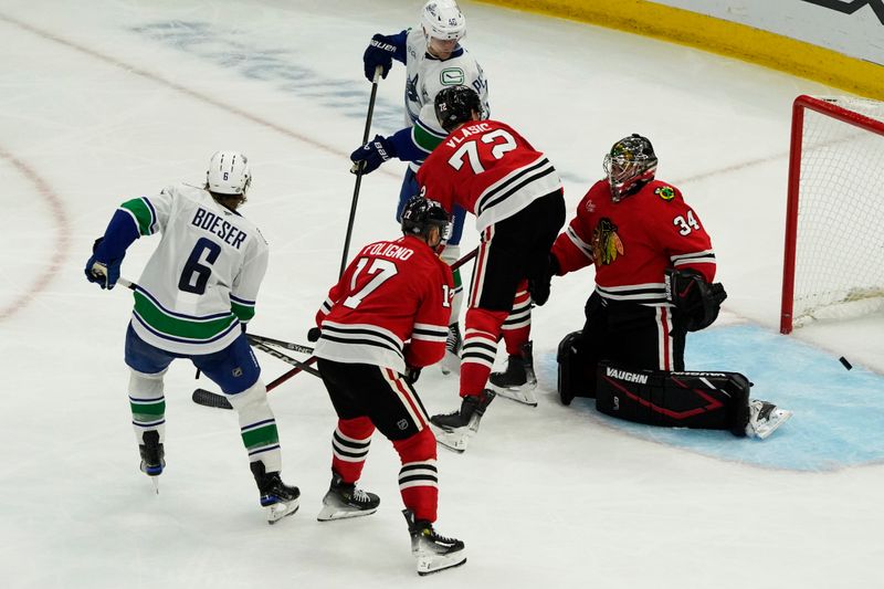 Oct 22, 2024; Chicago, Illinois, USA; Vancouver Canucks right wing Brock Boeser (6) scores a goal on Chicago Blackhawks goaltender Petr Mrazek (34) during the third period at United Center. Mandatory Credit: David Banks-Imagn Images