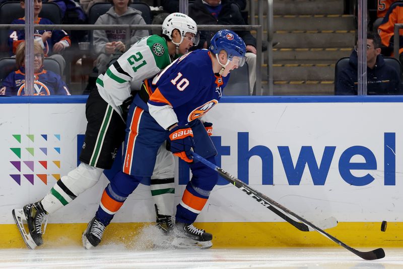 Jan 21, 2024; Elmont, New York, USA; Dallas Stars left wing Jason Robertson (21) fights for the puck against New York Islanders right wing Simon Holmstrom (10) during the third period at UBS Arena. Mandatory Credit: Brad Penner-USA TODAY Sports