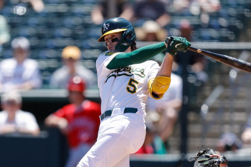 May 22, 2025; West Sacramento, California, USA; Athletics shortstop Jacob Wilson (5) hits a single during the first inning against the Los Angeles Angels at Sutter Health Park. Mandatory Credit: Sergio Estrada-Imagn Images