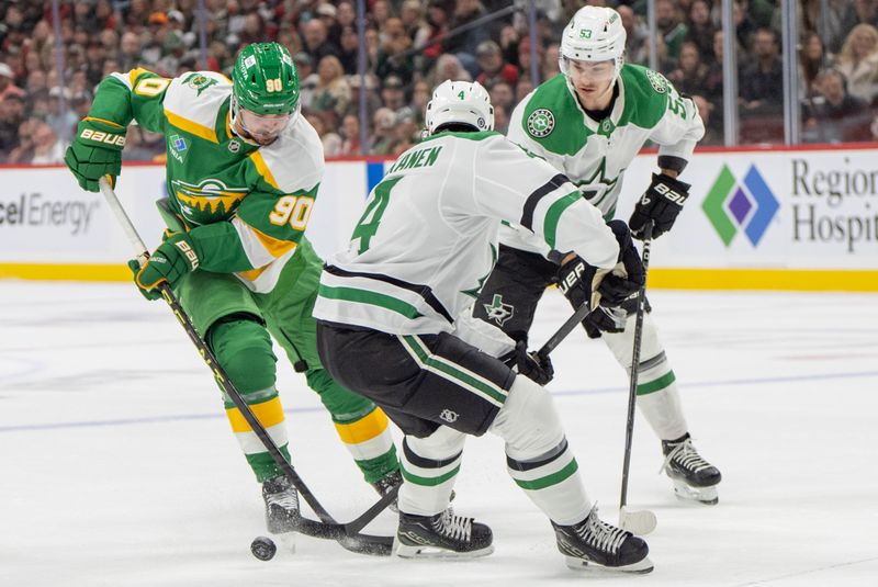 Nov 16, 2024; Saint Paul, Minnesota, USA; Minnesota Wild center Marcus Johansson (90) tries to get around Dallas Stars defenseman Miro Heiskanen (4) in the first period at Xcel Energy Center. Mandatory Credit: Matt Blewett-Imagn Images