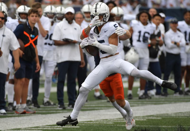 Sep 16, 2023; Champaign, Illinois, USA;  Penn State Nittany Lions cornerback Cam Miller (5) steps in front of Illinois Fighting Illini wide receiver Casey Washington (14) to intercept the ball during the second half at Memorial Stadium. Mandatory Credit: Ron Johnson-USA TODAY Sports