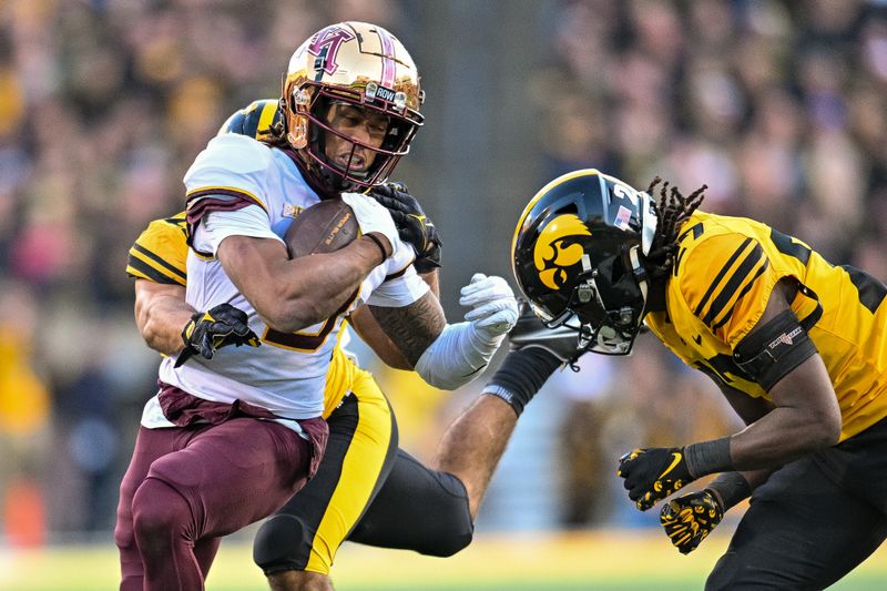 Oct 21, 2023; Iowa City, Iowa, USA; Minnesota Golden Gophers wide receiver Daniel Jackson (9) is tackled by Iowa Hawkeyes defensive back Jermari Harris (27) and defensive back Sebastian Castro (29) during the fourth quarter at Kinnick Stadium. Mandatory Credit: Jeffrey Becker-USA TODAY Sports