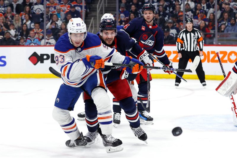 Mar 26, 2024; Winnipeg, Manitoba, CAN; Edmonton Oilers center Ryan Nugent-Hopkins (93) and Winnipeg Jets defenseman Dylan DeMelo (2) scramble for the puck in the first period at Canada Life Centre. Mandatory Credit: James Carey Lauder-USA TODAY Sports