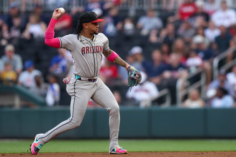 Jun 3, 2025; Atlanta, Georgia, USA; Arizona Diamondbacks second baseman Ketel Marte (4) throws a runner out at first against the Atlanta Braves in the third inning at Truist Park. Mandatory Credit: Brett Davis-Imagn Images