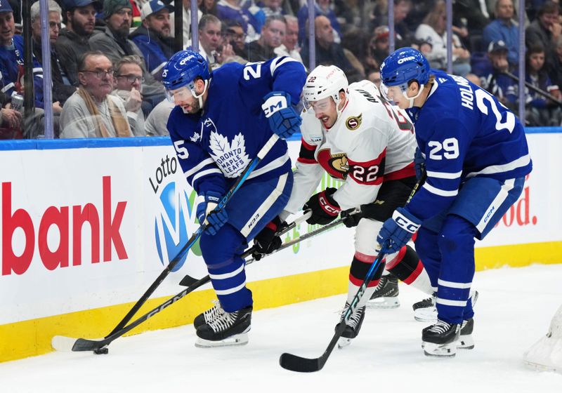 Nov 12, 2024; Toronto, Ontario, CAN; Ottawa Senators right wing Michael Amadio (22) battles for the puck with Toronto Maple Leafs defenseman Conor Timmins (25) during the second period at Scotiabank Arena. Mandatory Credit: Nick Turchiaro-Imagn Images