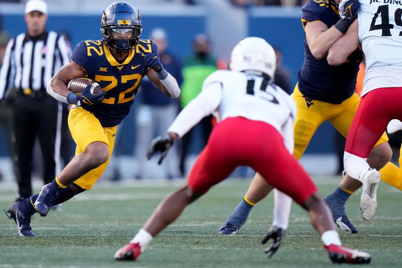 Nov 18, 2023; Morgantown, West Virginia, USA; West Virginia Mountaineers running back Jahiem White (22) carries the ball against he Cincinnati Bearcats in the third quarter at Milan Puskar Stadium. West Virginia won 42-21. Mandatory Credit: Kareem Elgazzar-USA TODAY Sports