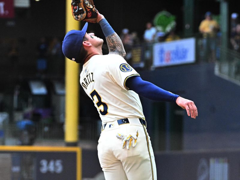 Jul 31, 2024; Milwaukee, Wisconsin, USA; Milwaukee Brewers third base Joey Ortiz (3) catches a fly ball against the Atlanta Braves in the first inning at American Family Field. Mandatory Credit: Michael McLoone-USA TODAY Sports