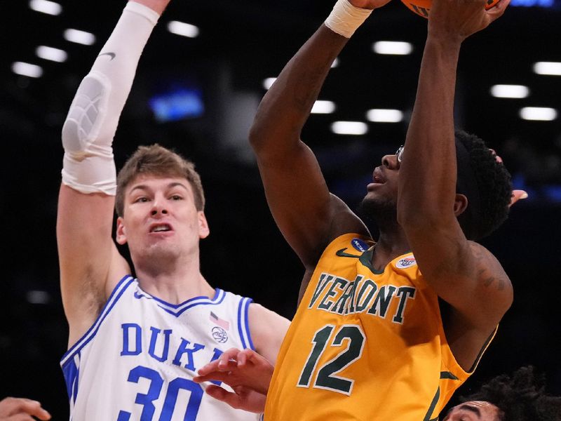 Mar 22, 2024; Brooklyn, NY, USA; Vermont Catamounts guard Shamir Bogues (12) shoots the ball against Duke Blue Devils center Kyle Filipowski (30) in the first round of the 2024 NCAA Tournament at the Barclays Center. Mandatory Credit: Robert Deutsch-USA TODAY Sports