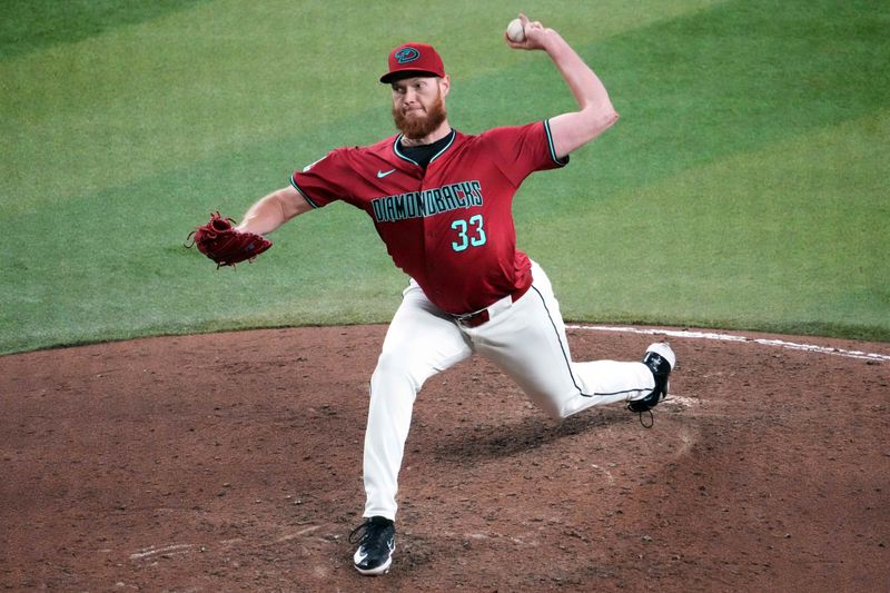 Jul 28, 2024; Phoenix, Arizona, USA; Arizona Diamondbacks pitcher A.J. Puk (33) pitches against the Pittsburgh Pirates during the seventh inning at Chase Field. Mandatory Credit: Joe Camporeale-USA TODAY Sports