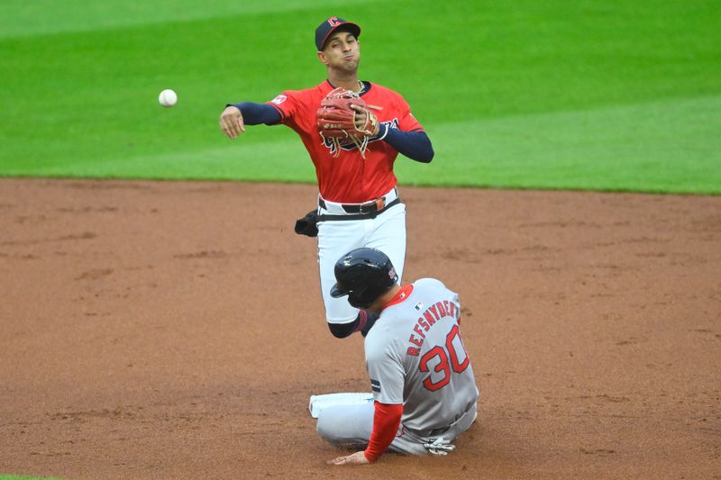 Apr 23, 2024; Cleveland, Ohio, USA; Cleveland Guardians shortstop Brayan Rocchio (4) turns a double play beside Boston Red Sox right fielder Rob Refsnyder (30) in the second inning at Progressive Field. Mandatory Credit: David Richard-USA TODAY Sports