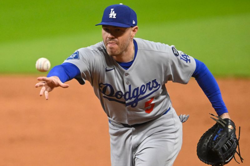 May 27, 2025; Cleveland, Ohio, USA; Los Angeles Dodgers first baseman Freddie Freeman (5) tosses the ball to first base in the ninth inning against the Cleveland Guardians at Progressive Field. Mandatory Credit: David Richard-Imagn Images