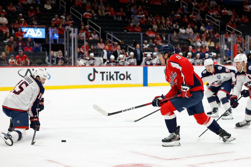 Oct 4, 2025; Washington, District of Columbia, USA; Washington Capitals right wing Ryan Leonard (9) shoots the puck as Columbus Blue Jackets defenseman Dante Fabbro (15) defends during the first period at Capital One Arena. Mandatory Credit: Geoff Burke-Imagn Images