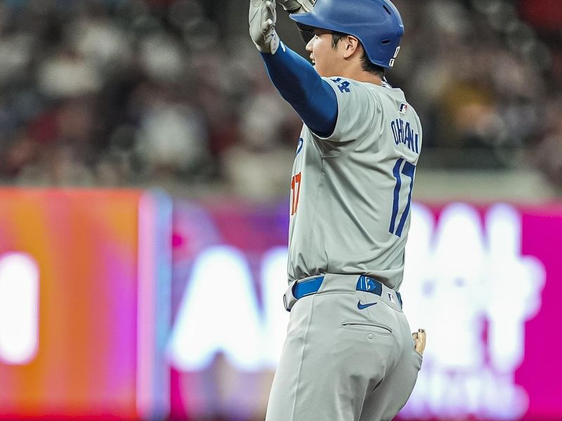 Sep 15, 2024; Cumberland, Georgia, USA; Los Angeles Dodgers designated hitter Shohei Ohtani (17) reacts after hitting a double to drive in a run against the Atlanta Braves during the seventh inning at Truist Park. Mandatory Credit: Dale Zanine-Imagn Images