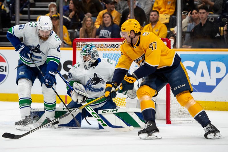 May 3, 2024; Nashville, Tennessee, USA; Vancouver Canucks goalkeeper Vancouver Canucks goalie Arturs Silovs (31) blocks the hot tof Vancouver Canucks defenseman Noah Juulsen (47) during the first period in game six of the first round of the 2024 Stanley Cup Playoffs at Bridgestone Arena. Mandatory Credit: Steve Roberts-USA TODAY Sports