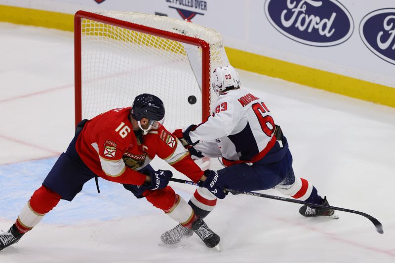 Nov 25, 2024; Sunrise, Florida, USA; Washington Capitals left wing Ivan Miroshnichenko (63) moves the puck past Florida Panthers center Aleksander Barkov (16) and scores a goal on an empty net during the third period at Amerant Bank Arena. Mandatory Credit: Sam Navarro-Imagn Images