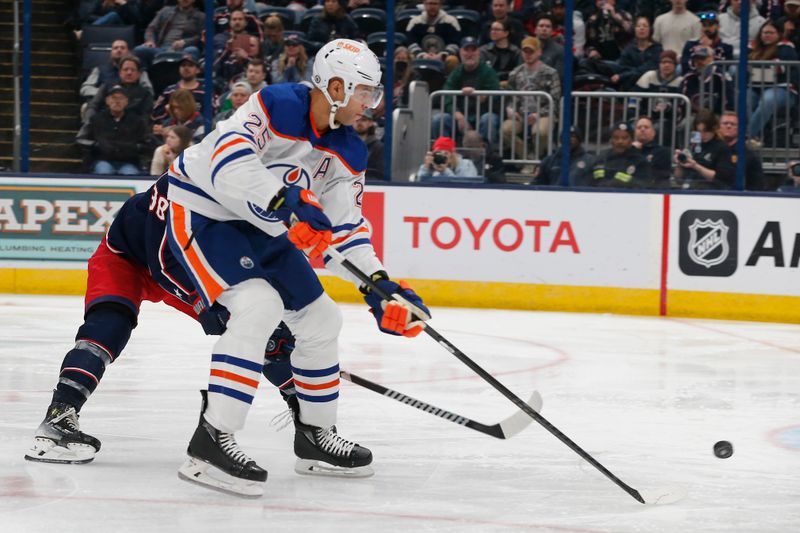 Mar 7, 2024; Columbus, Ohio, USA; Edmonton Oilers defenseman Darnell Nurse (25) tips the put on goal as Columbus Blue Jackets center Boone Jenner (38) trails the play during the third period at Nationwide Arena. Mandatory Credit: Russell LaBounty-USA TODAY Sports