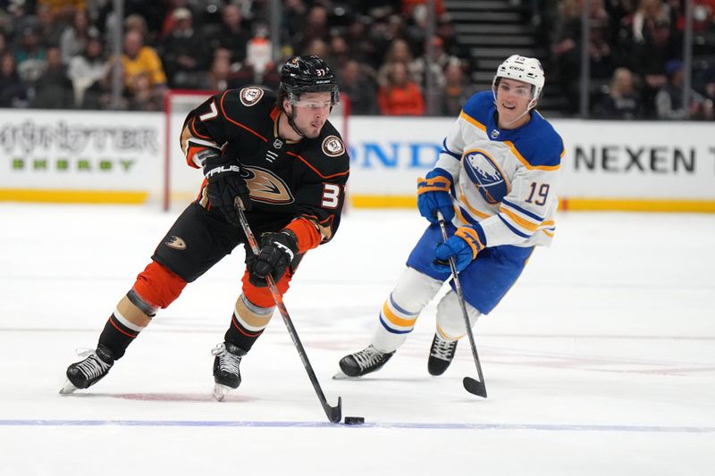 Feb 15, 2023; Anaheim, California, USA; Anaheim Ducks center Mason McTavish (37) skates with the puck pursued by Buffalo Sabres center Peyton Krebs (19) in the second period at Honda Center. Mandatory Credit: Kirby Lee-USA TODAY Sports